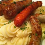 Assorted German grilled sausages with sauerkraut and mashed potatoes.