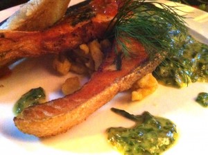 Salmon steak served with spinach cream and lemon butter, tomato salsa